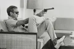 John Dominis, Steve McQueen aims a pistol in his living room, California, 1963, Gelatin silver print, printed later, flush-mounted