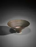 Footed bowl by Lucie Rie, 1983, Porcelain, golden manganese glaze, interior with terracotta and black rings on the well, sold Apr 2017