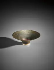 Footed bowl by Lucie Rie, circa 1972, Porcelain, golden manganese glaze, terracotta well, sold Apr 2017