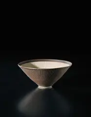Conical bowl by Lucie Rie, circa 1972, Porcelain, golden manganese glaze with sgraffito on the exterior, the interior unglazed with inlaid radiating design, sold Sep 2017