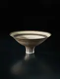 Flaring footed bowl by Lucie Rie, circa 1980, Porcelain, golden manganese glaze with concentric bands of inlay and sgraffito, sold Sep 2017