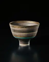 Lucie Rie, Straight-sided bowl, circa 1978, Porcelain, golden manganese glaze, two terracotta bands crossed with vertical sgraffito lines, terracotta well and a turquoise ring