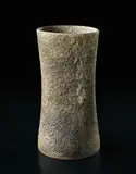 Flower vase by Lucie Rie, circa 1976, Grey and green pitted glaze over a stoneware body incised with diagonal design, sold Sep 2017