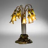 Twelve-light Lily table lamp by Tiffany Studios, c. 1910, patinated and acid-etched bronze, hand-blown Favrile glass, sold Nov 2025