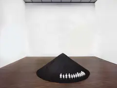 Alicja Kwade, Die Trinkenden, 2011, 12 Porzellanfiguren von Rosenthal (Entwurf Ernst Wenck 1924) auf Kohleberg auf Maße: Figuren: Höhe 11,5 x bis 16cm; Kohleberg: ca. 120 x Ø 300cmcm