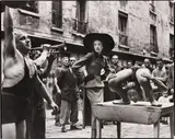 Richard Avedon, Elise Daniels with street performers, Suit by Balenciaga, Le Marais, Paris, August