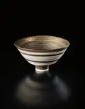 Conical bowl by Lucie Rie, 1976, Porcelain, golden manganese rim with bands of inlaid and sgraffito grid designs, sold Sep 2016