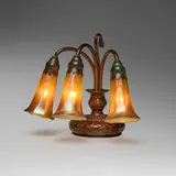 Three-light Lily piano lamp by Tiffany Studios, c. 1910, patinated bronze, hand-blown Favrile glass, sold Nov 2025