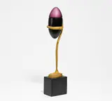 Paul Wunderlich, Ellipsoid (Form 1), 1978/79, Bronze, vergoldet, schwarzes Porzellan, mundgeblasenes Glas und Metallkette mit Kugel