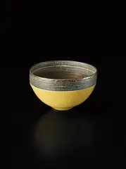 Bowl by Lucie Rie, circa 1976, Porcelain, pitted yellow and golden manganese glazes. A deep band of sgraffito grid repeated inside and out, sold Oct 2015