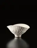 Lucie Rie, Large oval bowl with fluted design, circa 1975, Stoneware, cream pitted glaze with manganese speckle