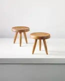 Pair of three-legged stools, from the l’Equipement de la Maison series by Charlotte Perriand and Pierre Jeanneret, designed 1949, Walnut, sold Sep 2013
