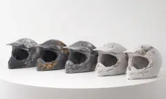 Eroded Motorcross Helmets by Daniel Arsham, 2015, glacial rock dust, obsidian fragments, steel fragments, hydrostone, sold Jun 2021