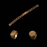 A Collection of Bracelet and Rings, Untitled, a.) A Curb-link ID Bracelet in 18k <br> The curb-link ID bracelet in 18k yellow gold features a central ID plate personalized with the engraving “Puno”. <br> The piece is accompanied by an extra link also in 18k. <br> Weighs 67.10 grams and 3.70 grams respectively. <br> <br> b.) A Monogram Ring in 18k <br> The 18k yellow gold ring features a JNP monogram in the center. <br> Weighs 20.90 grams. <br> <br> c.) A Signet Ring in 18k <br> The signet ring in 18k yellow gold features a coat of arms engraving in the center. <br> Hallmarked 750. <br> Weighs 15.60 grams.