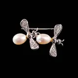A Bee Pin in 14k, Untitled, A 14k white gold pin designed as two bees with 8mm drop-shaped pearls accented by diamonds weighing approximately 0.06 cts. <br> Weighs 4.20 grams. <br> Diamond noted as Pass on the GIA iD100®