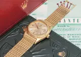 Rolex, An exceptionally rare and historically important yellow gold calendar wristwatch with centre seconds, red date, unusual bracelet, original guarantee and box