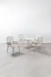 Jacques Dupuis, Ensemble de jardin comprenant une table et quatre fauteuils, Black lacquered wood, brass shoes and vinyl