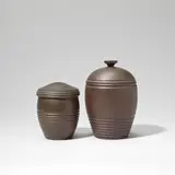 Two tobacco jars, model no.s 3865 and 3862 by Keith Murray: Made by Wedgwood, circa 1935, Earthenware, brown basalt glazes, sold Feb 2023