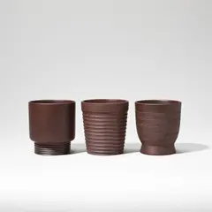 Keith Murray: Made by Wedgwood, Three beakers, circa 1935, Earthenware, brown basalt glaze, two of footed form (model no