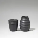 Two vases by Keith Murray: Made by Wedgwood, circa 1935, Earthenware, matt black basalt glaze, ribbed decoration, sold Feb 2023