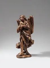 Flemish early 18th century, An early 18th century Flemish carved wooden figure of an angel., Carved in the round, the reverse only provisorily. Minor remains of former polychromy. A figure of an angel facing left. The sculpture's pained expression and folded arms point to a possible original placement as one of a pair of angels flanking the passion of Christ. With minor wear. The plinth subsequently carved from the original substance