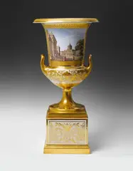 Königliche Porzellanmanufaktur Berlin Kpm, A Berlin KPM porcelain krater form vase with views of Potsdam., The bowl and base connected via a bronze rosette form screw mounting. The shoulders and socle with gilt tendril decor on a cream ground, the base and handles gilt and finely etched. Two rectangular fields containing a labelled view of the royal palace and town hall of Potsdam and a panoramic view of the city as seen from Brauhausberg. Blue sceptre mark, red imperial eagle mark, red planet mark. A shallow chip to the top of the base, a chip to the underside of the rim. H
