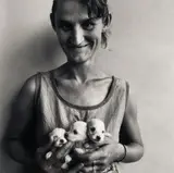 Roger Ballen, Wife of Abattoir worker holding three puppies, Orange Free State