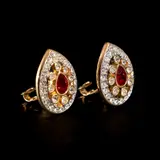 Untitled by A Pair of Swarvoski Earrings, The classic pair of gold-plated Swaroksi earrings feature a pear-shaped red Swarovski crystal in the center accented by , sold Jan 2026