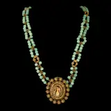 A Beaded Tamburin Necklace, Untitled, Crafted in brass, the Tamburin necklace showcases green round beads. It features a pendant depicting the Virgin Mary on the front and St. Joseph with the Child Jesus on the back.