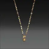 Untitled by A Beaded Tamburin Necklace in 12k, A beaded Tamburin necklace crafted in 12k gold, featuring intricately linked chains and gold beads. At the center hangs , sold Oct 2025