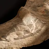 A highly unusual crescent–shaped shoulder wrap/
neckerchief for the “traje de mestiza” ensemble
(erroneously called “Maria Clara”), worn like a
fichu around the shoulders by Panuelo of Embroidered Piña Textile, handwoven piña textile with hand embroidery, sold Aug 2022