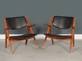 Paire de fauteuils mod. "CH28" dit "Sawbuck" by Hans J. Wegner, A pair of 'CH28' or 'Sawbuck' armchairs in teak and synthetic leather by Hans J, offered Nov 2023