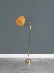 Lampadaire by Lisa Johansson-Pape, A floor lamp in brass and wood by Lisa Johansson-Pape circa 1950, offered Nov 2023