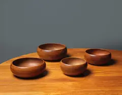Ensemble de quatre bols de service by Kay Bojesen, A set of four bowls in teak by Kay Bojesen designed circa 1955, offered Nov 2023