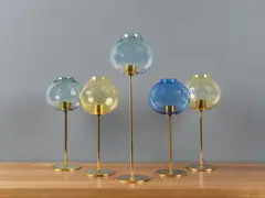 Ensemble de cinq bougeoirs mod. "135" by Hans Agne Jakobsson, A set of five '135' candlesticks by Hans-Agne Jakobsson in brass and colored glass designed circa 1960, edited by Hans-A, sold Nov 2023