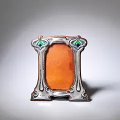 George Lawrence Connell, Photograph frame, 1904, Silver, embossed with stylised motifs decorated with green/purple enamel and mounted on an oak frame with a replacement leather back