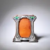 George Lawrence Connell, Photograph frame, 1904, Silver, embossed with stylised motifs decorated with green/purple enamel and mounted on an oak frame with a replacement leather back