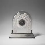 'Deux Figurines' mantel clock, designed 1926 by René Lalique, Clear glass, moulded and frosted, on illuminated metal pedestal mount, sold Dec 2023