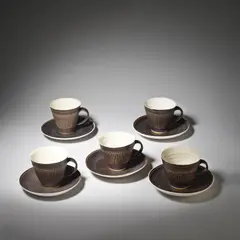 Five cups and saucers by Lucie Rie and Hans Coper, circa 1958, Stoneware, white and manganese glaze with sgraffito design, sold Dec 2023
