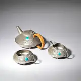 Archibald Knox, 'Tudric' three-piece teaset, model no. 0231, circa 1905, Pewter, enamel, wicker