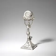 Figural clock by Wmf, circa 1900, Silver-plated metal, cast with an Art Nouveau maiden with two children and blackberries on the base, holding a timepiece, sold Jun 2023