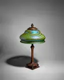Table lamp by Quezal Art Glass and Decorating Company, blown and iridescent glass, on patinated bronze base by Handel, shade engraved 'Quezal', sold Dec 2023