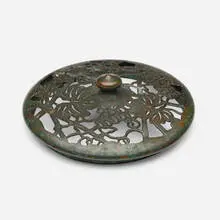 Grapevine heat cap by Tiffany Studios, c. 1910, patinated bronze, sold Jul 2025