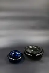 Per Lütken for Holmegaard, A blue tinted blown glass ash tray and a similar smokey glass bowl