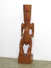 Pakariki Harrison, Carved kauri pouwhakairo figure. Modelled standing on plinth base with three-fingered hands to abdomen and red painted tamoko.