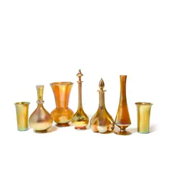 Group of Seven Table Objects by Frederick Carder, for Steuben, Aurene glass, comprising three vases, two decanters, and two beakers, all signed, sold Mar 2022