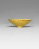 Footed bowl by Lucie Rie, circa 1965, Porcelain, yellow glaze, manganese lip, sold Apr 2022