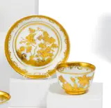 Meissen, Koppchen mit Unterschale mit goldradierten ostasiatischen Blumen, Porzellan, blauer Unterglasurdekor, reich überdekoriert in radierter Goldbemalung.