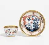 Tasse und Untertasse mit Fels- und Vogeldkor by Meissen, Um 1730/35, Hausmalerdekor der Werkstatt F.J. Ferner zugeschrieben, Porzellan, unterglasurblaues Dekor, farbig und gold staffiert, sold May 2022