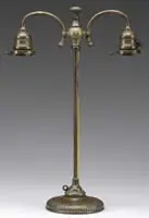 Double Student Lamp Base by Tiffany Studios, Each arm would support an art glass shade having a 2-1/4″ fitter rim, sold Jun 2010